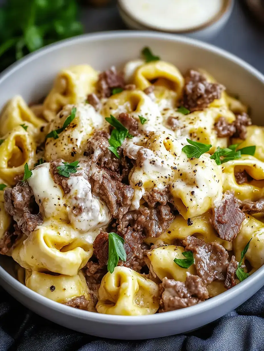 Un bol de tortellinis crémeux au bœuf épicé et garnis de persil frais.