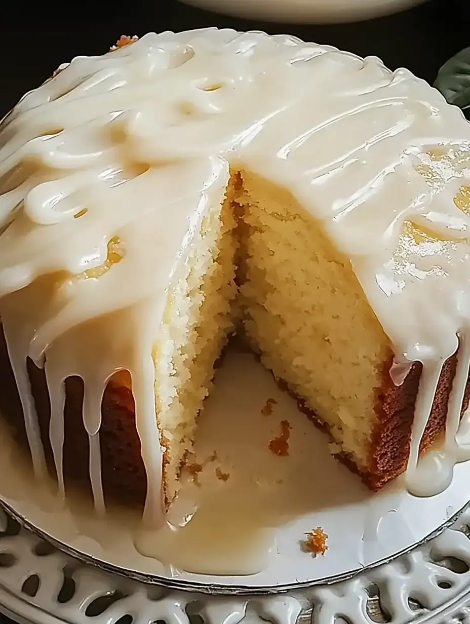 Un gâteau fraîchement cuit nappé de glaçage crème, déjà entamé pour révéler sa texture tendre.