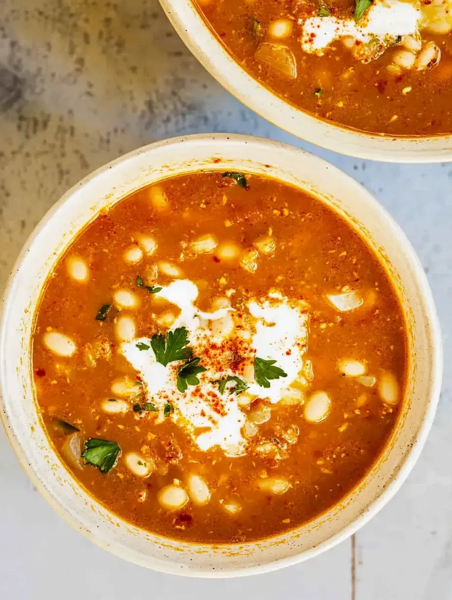 Zoom sur deux bols de soupe, crème fraîche, persil et une pointe d’épices dessus.